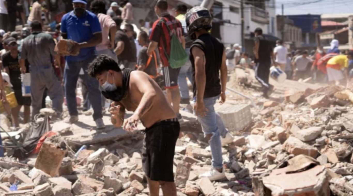 Voluntarios retirando escombros en una calle destruida de Cali
